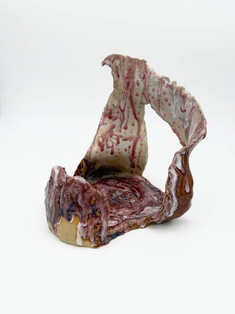 Adelina Ruvalcaba's ceramic sculpture titled: "A Place Where One Aspires." An abstract sculpture with negative space glazed with white and red.